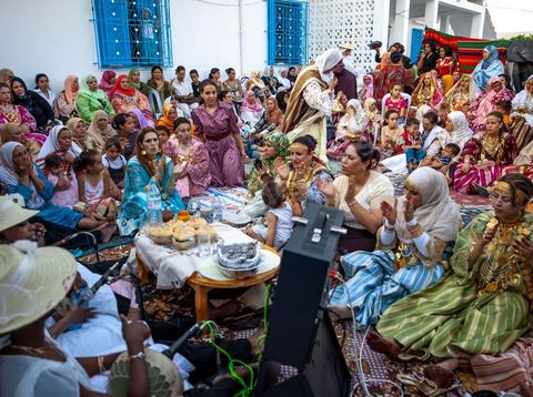 Lors d'un mariage traditionnel à Djerba, la soirée des femmes rassemble la communauté autour de la mariée, parée de la haajba, la tenue nuptiale djerbienne aux ornements précieux transmise de génération en génération. La musique est portée par des chanteuses et musiciens noirs, descendants des communautés subsahariennes établies sur l'île, qui animent la fête au son de la darbouka et du tambour, dans une tradition musicale propre au mariage djerbien.