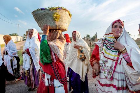 Avant le mariage, un cortège traverse les villages et la campagne de Djerba pour transporter le trousseau et les cadeaux offerts à la mariée, portés dans des couffins décorés. La marche est ouverte par des musiciens traditionnels, tambour et zokra en tête, qui annoncent le passage du cortège de maison en maison. Femmes et enfants du voisinage se joignent au passage, dans une ambiance de fête qui marque l'un des temps forts des préparatifs du mariage djerbien.