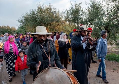 Avant le mariage, un cortège traverse les villages et la campagne de Djerba pour transporter le trousseau et les cadeaux offerts à la mariée, portés dans des couffins décorés. La marche est ouverte par des musiciens traditionnels, tambour et zokra en tête, qui annoncent le passage du cortège de maison en maison. Femmes et enfants du voisinage se joignent au passage, dans une ambiance de fête qui marque l'un des temps forts des préparatifs du mariage djerbien.
