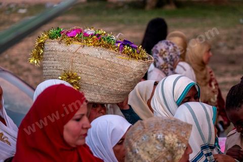 Avant le mariage, un cortège traverse les villages et la campagne de Djerba pour transporter le trousseau et les cadeaux offerts à la mariée, portés dans des couffins décorés. La marche est ouverte par des musiciens traditionnels, tambour et zokra en tête, qui annoncent le passage du cortège de maison en maison. Femmes et enfants du voisinage se joignent au passage, dans une ambiance de fête qui marque l'un des temps forts des préparatifs du mariage djerbien.