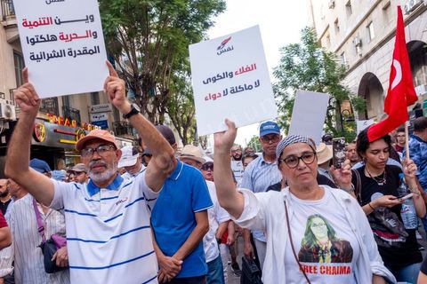 Tunis, Tunisie – 20 août 2026. Des manifestants défilent dans le centre de Tunis contre le président Kaïs Saïed, appelant à son départ et réclamant davantage de libertés politiques et la libération de détenus et opposants. Portraits du président barrés du slogan « DÉGAGE », drapeaux tunisiens et pancartes accompagnent la manifestation. La mobilisation intervient dans un contexte de mécontentement social croissant après plusieurs semaines de fortes chaleurs, de coupures d’eau et d’électricité et de difficultés d’accès à certains médicaments et produits essentiels.