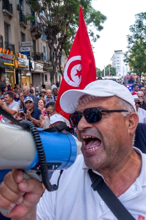 Tunis, Tunisia – August 20, 2026. Protesters march through downtown Tunis against President Kaïs Saïed, calling for his resignation and demanding greater political freedoms and the release of detainees and opposition figures. Portraits of the president crossed out with the slogan “GET OUT,” Tunisian flags, and signs accompany the protest. The protest comes amid growing social discontent following several weeks of extreme heat, water and power outages, and difficulties in accessing certain medications and essential goods.