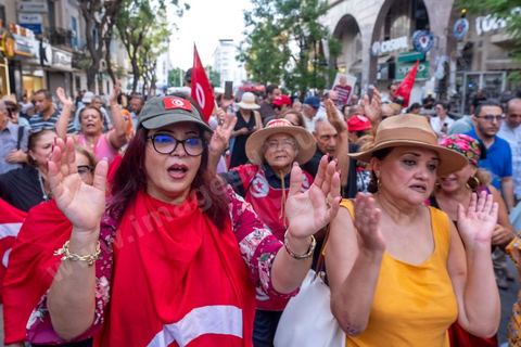 Tunis, Tunisia – August 20, 2026. Protesters march through downtown Tunis against President Kaïs Saïed, calling for his resignation and demanding greater political freedoms and the release of detainees and opposition figures. Portraits of the president crossed out with the slogan “GET OUT,” Tunisian flags, and signs accompany the protest. The protest comes amid growing social discontent following several weeks of extreme heat, water and power outages, and difficulties in accessing certain medications and essential goods.