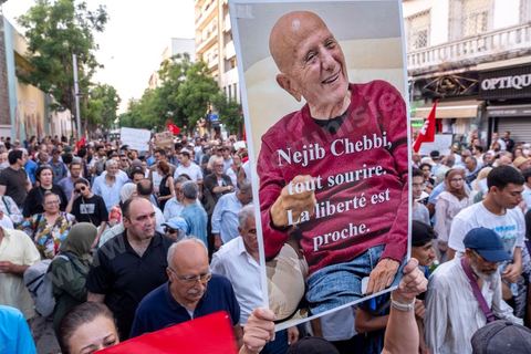 Tunis, Tunisia – August 20, 2026. Protesters march through downtown Tunis against President Kaïs Saïed, calling for his resignation and demanding greater political freedoms and the release of detainees and opposition figures. Portraits of the president crossed out with the slogan “GET OUT,” Tunisian flags, and signs accompany the protest. The protest comes amid growing social discontent following several weeks of extreme heat, water and power outages, and difficulties in accessing certain medications and essential goods.