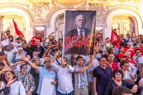 Tunis, Tunisia – August 20, 2026. Protesters march through downtown Tunis against President Kaïs Saïed, calling for his resignation and demanding greater political freedoms and the release of detainees and opposition figures. Portraits of the president crossed out with the slogan “GET OUT,” Tunisian flags, and signs accompany the protest. The protest comes amid growing social discontent following several weeks of extreme heat, water and power outages, and difficulties in accessing certain medications and essential goods.
