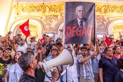 Tunis, Tunisia – August 20, 2026. Protesters march through downtown Tunis against President Kaïs Saïed, calling for his resignation and demanding greater political freedoms and the release of detainees and opposition figures. Portraits of the president crossed out with the slogan “GET OUT,” Tunisian flags, and signs accompany the protest. The protest comes amid growing social discontent following several weeks of extreme heat, water and power outages, and difficulties in accessing certain medications and essential goods.