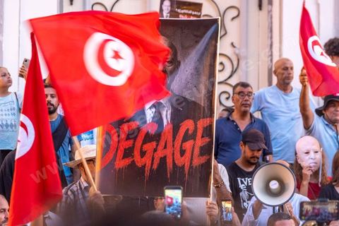 Tunis, Tunisia – August 20, 2026. Protesters march through downtown Tunis against President Kaïs Saïed, calling for his resignation and demanding greater political freedoms and the release of detainees and opposition figures. Portraits of the president crossed out with the slogan “GET OUT,” Tunisian flags, and signs accompany the protest. The protest comes amid growing social discontent following several weeks of extreme heat, water and power outages, and difficulties in accessing certain medications and essential goods.