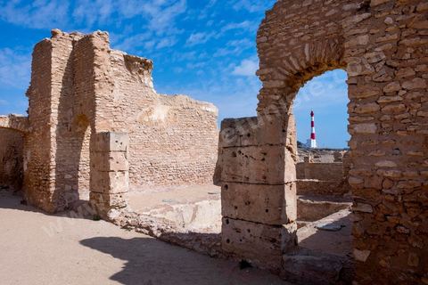 Thyna – l’antique Thaenae – est l’un des principaux sites archéologiques de la région de Sfax, situé à une douzaine de kilomètres au sud de la ville, sur le littoral tunisien. Ancienne cité punique, elle passe sous domination numide après la chute de Carthage en 146 av. J.-C., puis devient romaine en 46 av. J.-C. Élevée au rang de colonie au IIᵉ siècle, Thaenae connaît une importante prospérité durant l’époque romaine et reste occupée jusqu’à l’Antiquité tardive. Au IVᵉ siècle, la ville est protégée par une imposante enceinte de près de trois kilomètres, ponctuée de 84 tours et de trois portes. Aujourd’hui, le site conserve notamment les vestiges de ses remparts, de plusieurs établissements thermaux, dont les Thermes des Mois, de maisons antiques comme la Maison de Dionysos, ainsi que de vastes ensembles funéraires et nécropoles. Encore largement inexplorée, Thaenae fait aujourd’hui l’objet de nouvelles campagnes de recherches archéologiques et de valorisation.