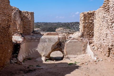 Thyna – l’antique Thaenae – est l’un des principaux sites archéologiques de la région de Sfax, situé à une douzaine de kilomètres au sud de la ville, sur le littoral tunisien. Ancienne cité punique, elle passe sous domination numide après la chute de Carthage en 146 av. J.-C., puis devient romaine en 46 av. J.-C. Élevée au rang de colonie au IIᵉ siècle, Thaenae connaît une importante prospérité durant l’époque romaine et reste occupée jusqu’à l’Antiquité tardive. Au IVᵉ siècle, la ville est protégée par une imposante enceinte de près de trois kilomètres, ponctuée de 84 tours et de trois portes. Aujourd’hui, le site conserve notamment les vestiges de ses remparts, de plusieurs établissements thermaux, dont les Thermes des Mois, de maisons antiques comme la Maison de Dionysos, ainsi que de vastes ensembles funéraires et nécropoles. Encore largement inexplorée, Thaenae fait aujourd’hui l’objet de nouvelles campagnes de recherches archéologiques et de valorisation.
