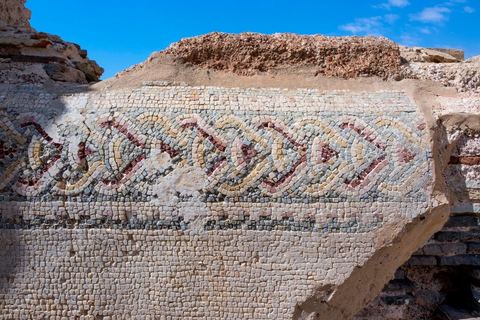 Thyna – l’antique Thaenae – est l’un des principaux sites archéologiques de la région de Sfax, situé à une douzaine de kilomètres au sud de la ville, sur le littoral tunisien. Ancienne cité punique, elle passe sous domination numide après la chute de Carthage en 146 av. J.-C., puis devient romaine en 46 av. J.-C. Élevée au rang de colonie au IIᵉ siècle, Thaenae connaît une importante prospérité durant l’époque romaine et reste occupée jusqu’à l’Antiquité tardive. Au IVᵉ siècle, la ville est protégée par une imposante enceinte de près de trois kilomètres, ponctuée de 84 tours et de trois portes. Aujourd’hui, le site conserve notamment les vestiges de ses remparts, de plusieurs établissements thermaux, dont les Thermes des Mois, de maisons antiques comme la Maison de Dionysos, ainsi que de vastes ensembles funéraires et nécropoles. Encore largement inexplorée, Thaenae fait aujourd’hui l’objet de nouvelles campagnes de recherches archéologiques et de valorisation.