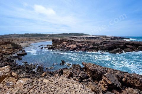 La côte d'El Haouaria à la pointe du Cap Bon, falaise, mer et montagnes. Baie avec plage et barques de pêcheurs.