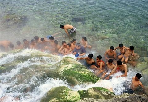 Baignade dans une source d'eau chaude jaillissant dans la mer a la ville thermale de Korbous