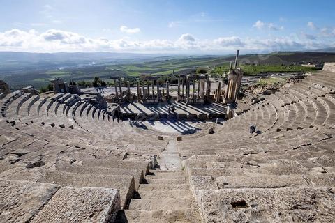 Théâtre antique de Dougga. Le site de Dougga, classé au patrimoine mondial de l'UNESCO, Situé sur un éperon dominant la riche vallée de la Mejerdah, le site s'étend sur plusieurs dizaines d'hectares et couvre plusieurs ères historiques. L’excellent état de conservation de la plupart des monuments qui le composent dont certains, tels le capitole ou le théâtre, ont été « remis sur pied » au cours d’une campagne menée au lendemain de la première guerre mondiale par des prisonniers de guerre.