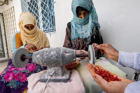 les ouvrières taillent et polissent le corail dans l'atelier de Mokthar, installé dans la cour de sa maison à Tabarka