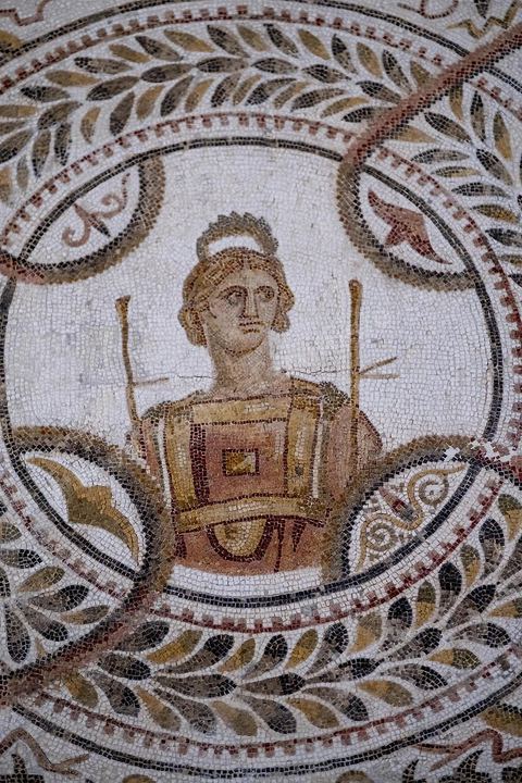 Détails de la mosaïque des neufs muses représentées à l'interieur de couronnes de laurier, fin du IIIème siècle après JC. Le musée archéologique de El Djem, cité antique de Thysdrus, a été aménagé à l’emplacement d’une villa romaine dont il restitue l’organisation spatiale : une cour centrale entourée d’un péristyle – préau – qui donne accès aux chambres. Là, sont exposés des objets – sculptures, tableaux en mosaïque, céramique, etc. – provenant de campagnes de fouilles menées à Thysdrus aussi bien que dans les environs de la cité.