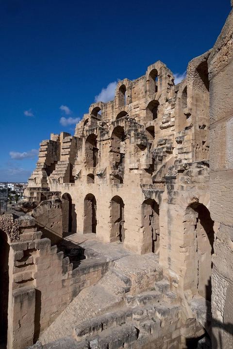 Amphithéâtre romain de El Djem. C’est le monument romain d’Afrique du Nord, de loin le plus imposant, sa silhouette ronde et massive s’élève dans une plaine plate et désertique qui le laisse voir à très longue distance. De forme presque elliptique, le monument mesure 149 m de long sur 124 m de large et 36m de haut. Les gradins, aujourd’hui disparus et partiellement reconstitués, pouvaient accueillir jusqu’à 30.000 spectateurs