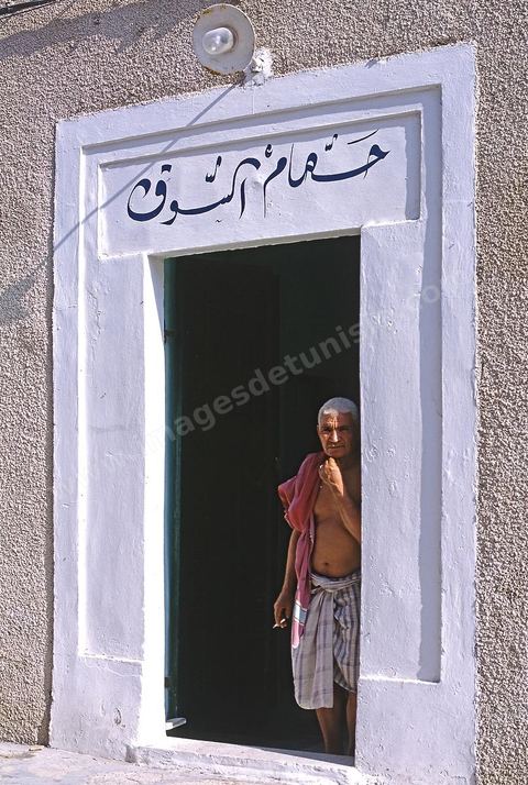 Homme à l'entrée d'un hammam dans la medina de Mahdia