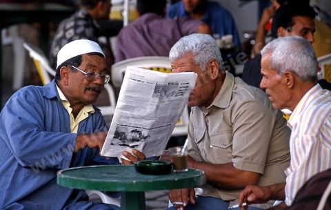 Hommes lisant le journal au café sur la place du caire dans la medina de Mahdia