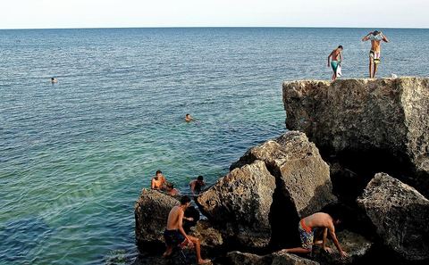 enfants plongeant depuis des rochers à Mahdia