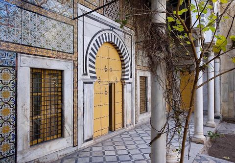 Patio à jardin du Dar Othman palais de la medina de Tunis - porte jaune ancienne et mur de céramiques