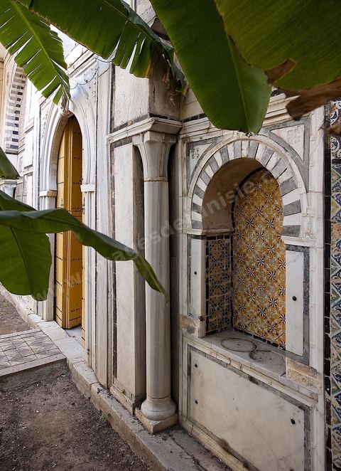 Patio à jardin du Dar Othman palais de la medina de Tunis - porte jaune ancienne et mur de céramiques
