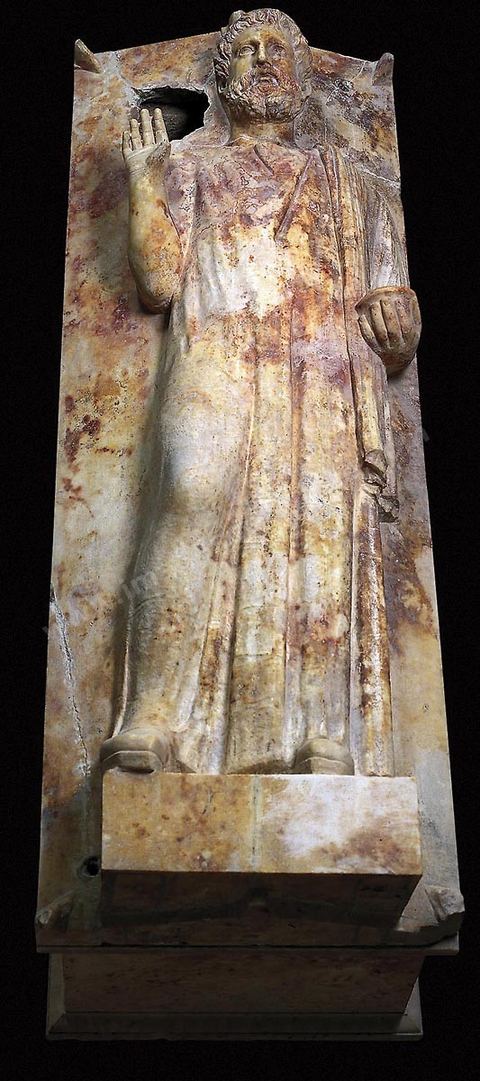 Sarcophage en marbre blanc à couvercle figuré orné en haut-relief d'un personnage masculin portant moustache et barbe dont le coprs est enveloppé d'un long vétement. La main droite est levée dans un geste de prière te la gauche tient une coupe. On y a vu un prêtre ou un magistrat. L'influence égyptienne est perceptible ainsi que celle de la Grèce (H. 65 cm, L. 193 cm, l. 72 cm, nécropole de sainte Monique à Carthage, IIIème siècle avant JC, musée de Carthage).