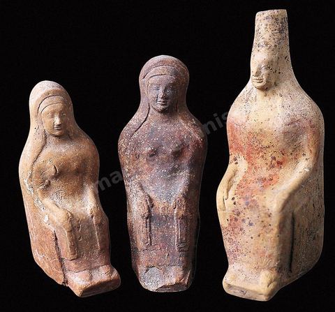 Déesses assises sur des trônes, enveloppées d'un voile descendant jusqu'à leurs genoux. L'une d'elles est coiffée d'une tiare cylindrique. Ces figurines se rattachent à des modèles ioniens de la fin du Vième sicèle avant JC (H. 13 à 16 cm, musée de Carthage).