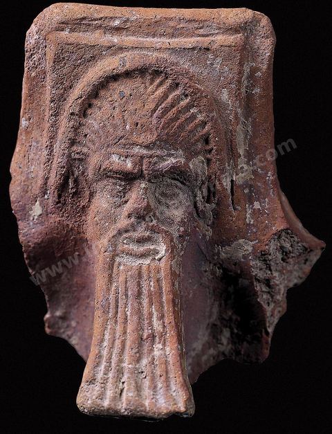 Tenon de brasero figurant une tête ornée d'une barbe (Musée de Carthage).