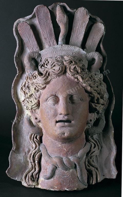 Masque en terre cuite représentant sans doute Déméter. La déesse porte une sorte de tiare en boisseau, encadré d'un voile rigide en forme de conque. Des plumes verticales et parallèles s'en élèvent, au centre desquelles se détachent un serpent, attribut habituel des divinités chtoniennes (H. 46 cm, l. 29 cm, ép. 12,5 cm, sanctuaire de Salammbô, Carthage, III-IIème siècle avant JC, musée de Carthage).