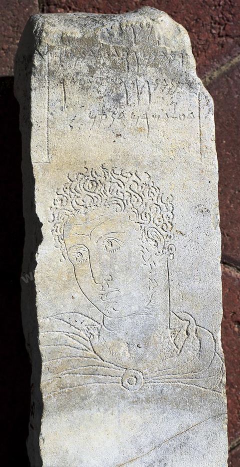 stele votive en calcaire gris portant une inscription au dessous d laquelle a été gravé un visage d'adolescent vêtu d'une chlamyde, dont le regard statique et lointain semble interroger le monde invisible. L'intensité de l'expression, remarquable, peut-être rapprochée de l'art grec ou hellénistique (H. 75 cm, l. 16 cm,  III siècle av. JC, Tophet, Carthage, musée de Carthage