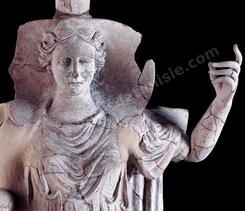 Statue de Déméter en terre cuite, presque grandeur nature, assise sur un trône en posture divine, vêtue d’une robe plissée, la tête coiffée d’une tiare cylindrique en forme de boisseau ou polos, et encadrée d’un voile rigide évoquant une conque. Son culte et celui de Coré furent officiellement introduits à Carthage en 396‑av. J.-C. pour réparer la profanation d’un de ses temples à Syracuse. Très présente dans les sanctuaires ruraux du Cap Bon, on l’y trouve tantôt associée à Baal Hammon et Tanit , tantôt accompagnée de ses parèdres Coré et Pluton, comme à Korba. Elle semble porter la réminiscence d’un modèle dû aux coroplathes siciliens des IVe-IIIe siècles av. J.-C. ( sanctuaire rural près de Korba , fin‑IVe-début IIIe siècle av. J.-C., musée du Bardo ).