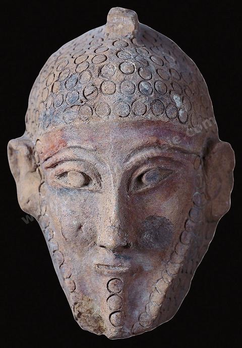 Masque d’homme en terre cuite. Ces masques pleins et gravés semblent aptes à attirer la bienveillance et la protection des puissances bénéfiques (H. 20‑cm, Carthage, début du‑Ve‑siècle av.‑J.-C., musée du Bardo). section punique - musée du Bardo